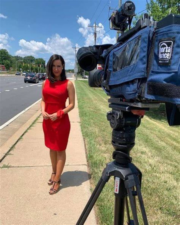 Katie Katro in a red dress poses for a picture.
