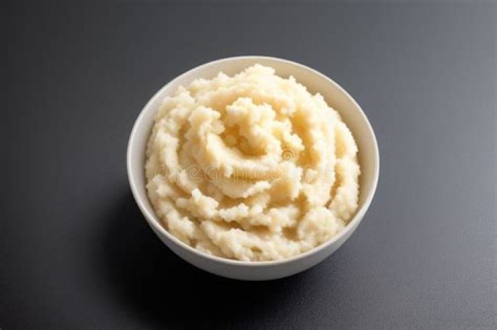 Mashed bananas in a white bowl.